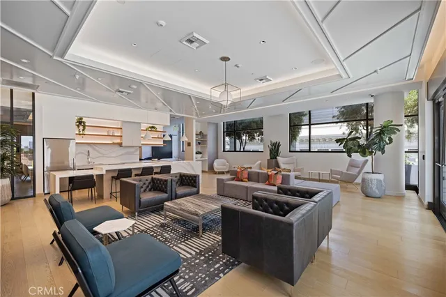 a living room with furniture kitchen view and a large window