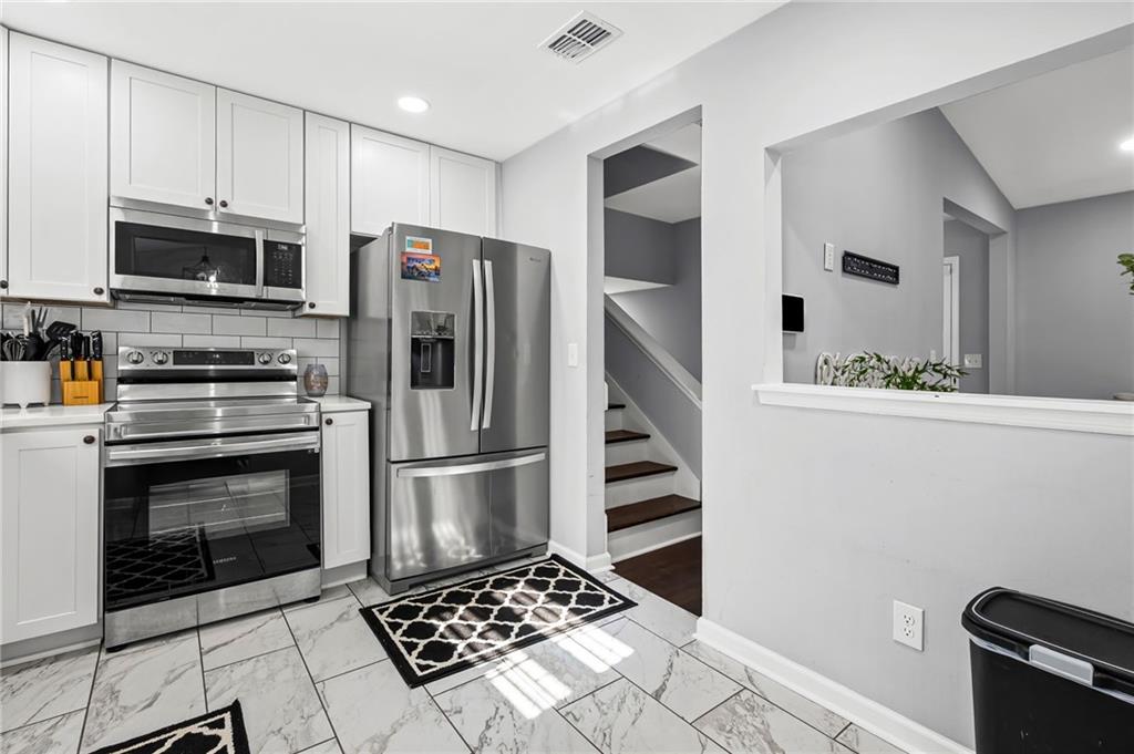 2468 Leslie Brook Drive Decatur, GA 30035 - Photo 13 of 39 a kitchen with stainless steel appliances a stove a microwave and a refrigerator