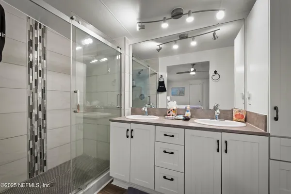 a bathroom with a shower sink and mirror