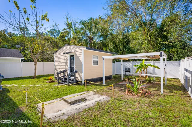 an aerial view of residential houses with outdoor space and trees