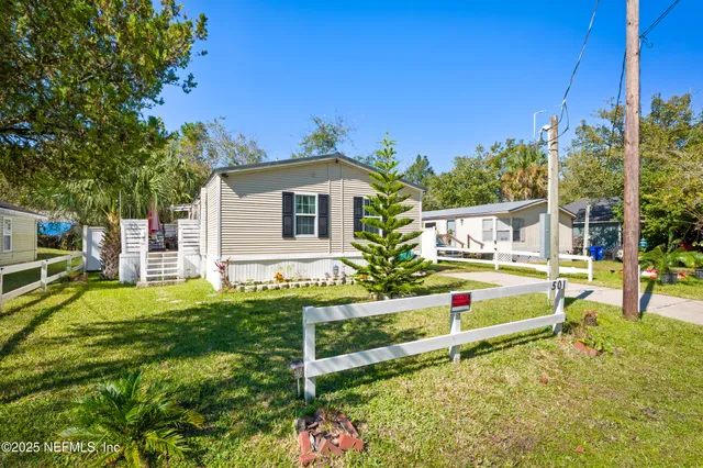 an aerial view of residential houses with outdoor space and trees