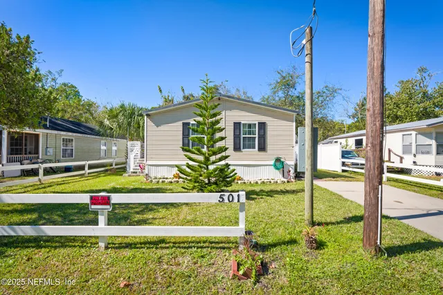 an aerial view of residential houses with outdoor space and trees