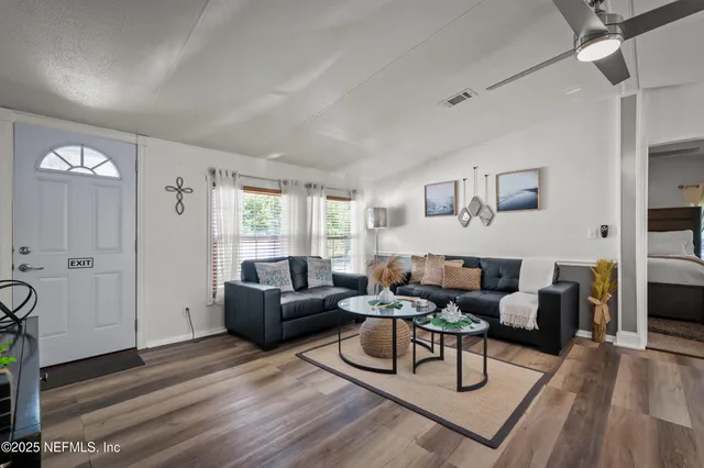 a living room with furniture and a wooden floor