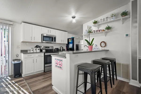 a kitchen with granite countertop a sink a stove and cabinets