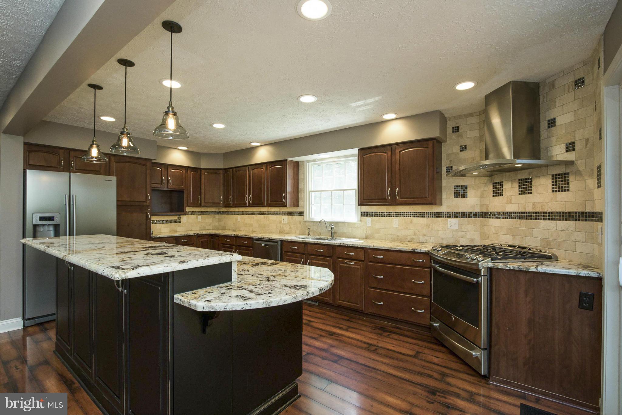 610 Running Fox Road Lusby, MD 20657 - Photo 7 of 30 a kitchen with stainless steel appliances granite countertop a sink stove and cabinets