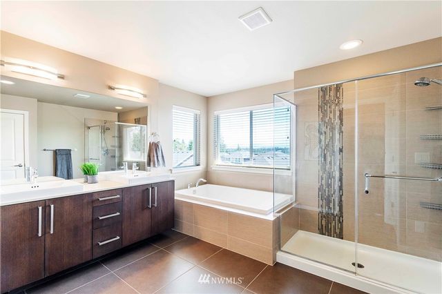 a bathroom with a tub sink shower and mirror