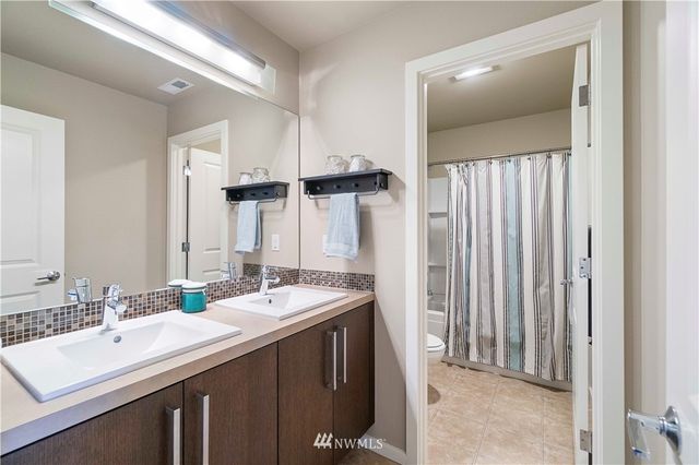 a bathroom with a double vanity sink and a mirror