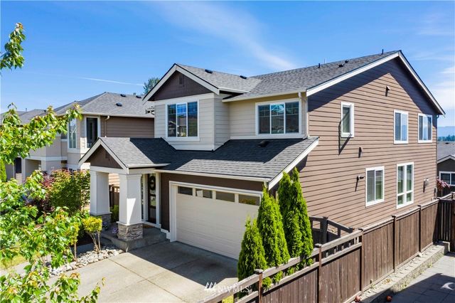 a front view of house with yard and trees in the background