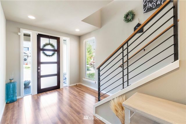 a view of an entryway with wooden floor and cabinet
