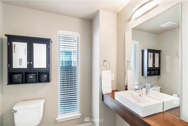 a bathroom with a toilet a sink and mirror