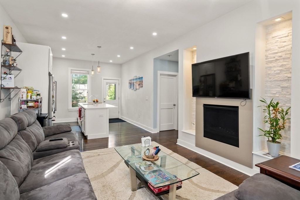 59 Mozart Street, Unit 1 Boston, MA 02130 - Photo 4 of 22 a living room with furniture a fireplace and a flat screen tv