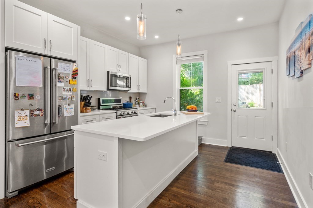 59 Mozart Street, Unit 1 Boston, MA 02130 - Photo 6 of 22 a kitchen with stainless steel appliances a refrigerator sink and microwave