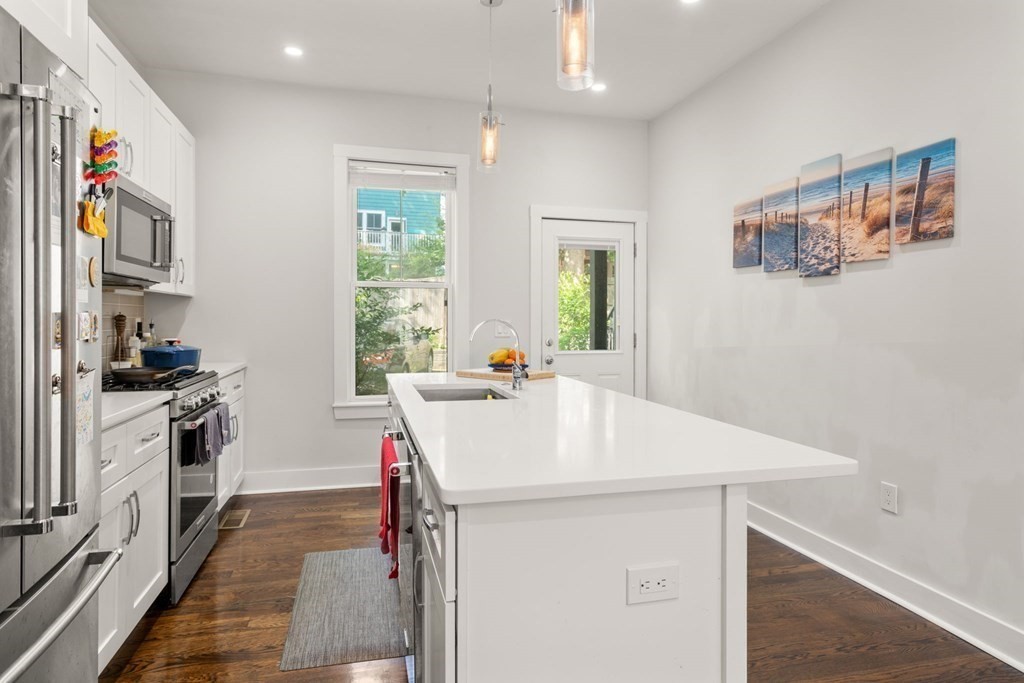 59 Mozart Street, Unit 1 Boston, MA 02130 - Photo 7 of 22 a kitchen with a sink a stove and a refrigerator