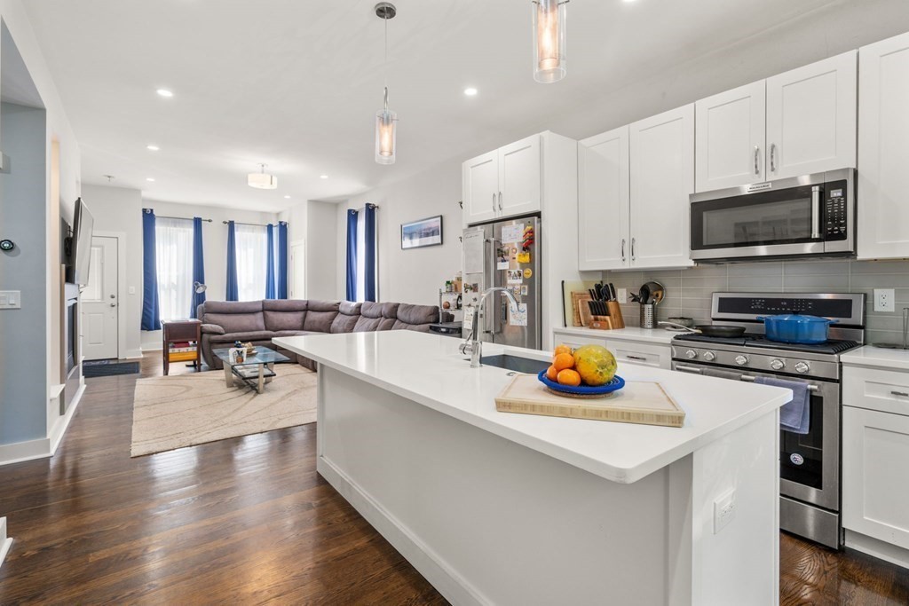 59 Mozart Street, Unit 1 Boston, MA 02130 - Photo 8 of 22 a kitchen with stainless steel appliances a stove a sink a microwave a refrigerator and cabinets