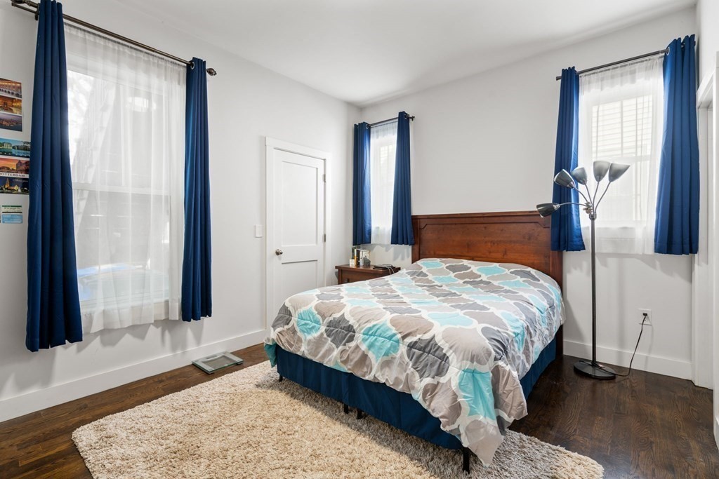 59 Mozart Street, Unit 1 Boston, MA 02130 - Photo 9 of 22 a bedroom with a bed lamp and a window