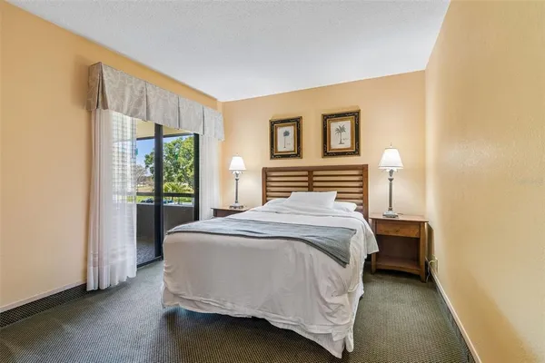 a spacious bedroom with a bed and a flat screen tv