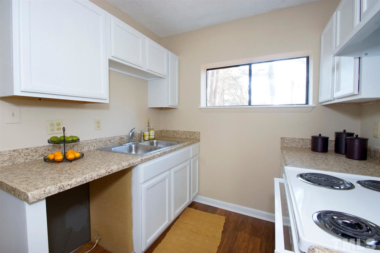 5924 Farm Gate Road Raleigh, NC 27606 - Photo 7 of 17 a kitchen with a sink a stove and cabinets