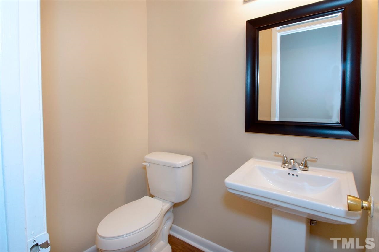 5924 Farm Gate Road Raleigh, NC 27606 - Photo 8 of 17 a bathroom with a toilet a sink and mirror