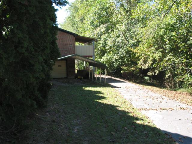 Rear of home with carport, garage entrance and covered porch