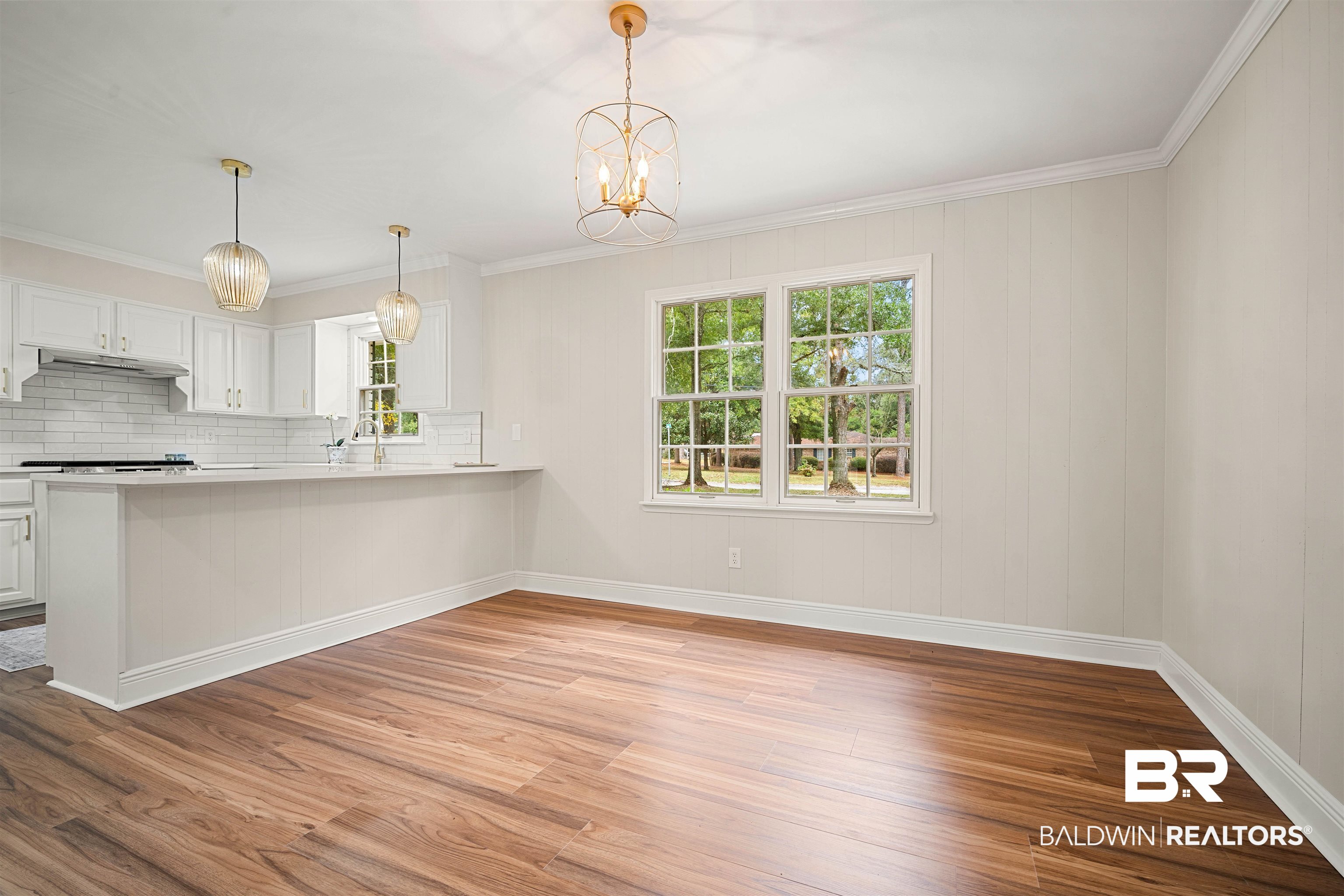 3050 Lacoste Road Mobile, AL 36618 - Photo 9 of 30 Kitchen featuring crown molding, white cabinets, light wood-style flooring, plenty of natural light, and decorative light fixtures