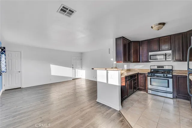 a kitchen with granite countertop a stove top oven and cabinets
