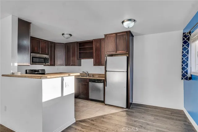 a kitchen with granite countertop stainless steel appliances a refrigerator and a stove top oven