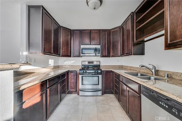 a kitchen with stainless steel appliances granite countertop a sink stove and cabinets