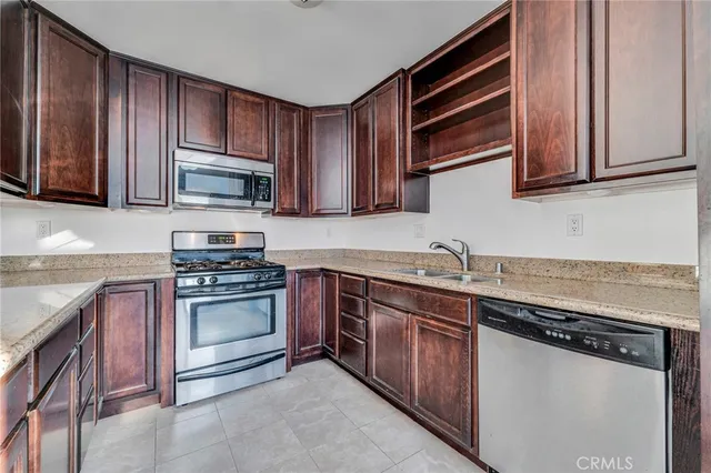 a kitchen with stainless steel appliances granite countertop a sink stove and microwave