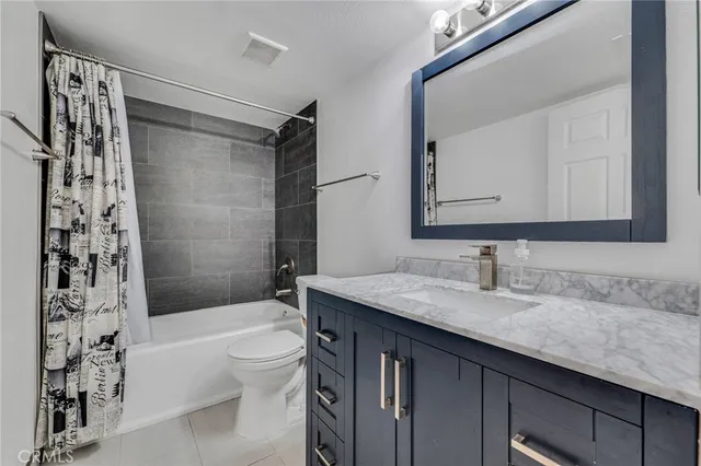 a bathroom with a granite countertop sink a toilet and shower