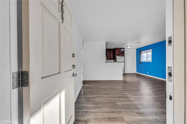 a view of an empty room with window and wooden floor