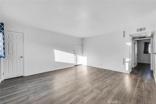 an empty room with wooden floor and a window