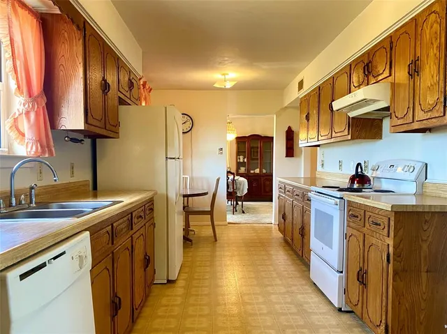 a kitchen with stainless steel appliances granite countertop a sink a stove and a refrigerator