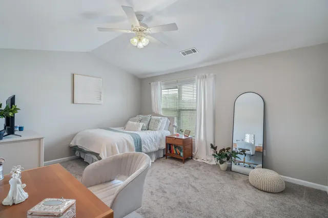 a bedroom with bed and a large window