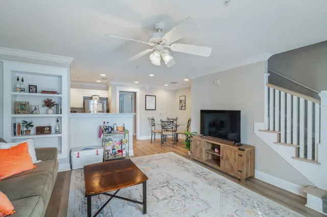 a living room with stainless steel appliances a dining table chairs stove and kitchen view