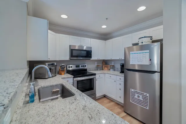 a kitchen with stainless steel appliances a refrigerator sink and microwave