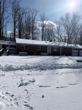 a view of a house with snow on the road