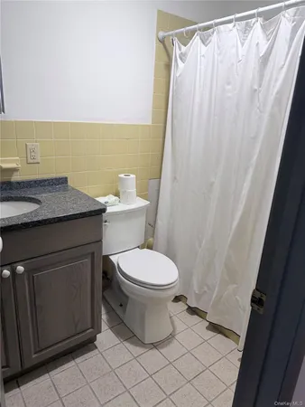 a bathroom with a granite countertop toilet and a sink