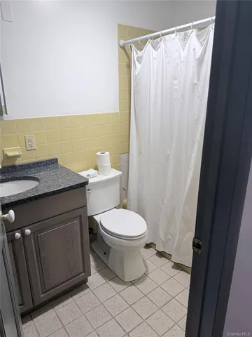 a bathroom with a granite countertop toilet and a sink