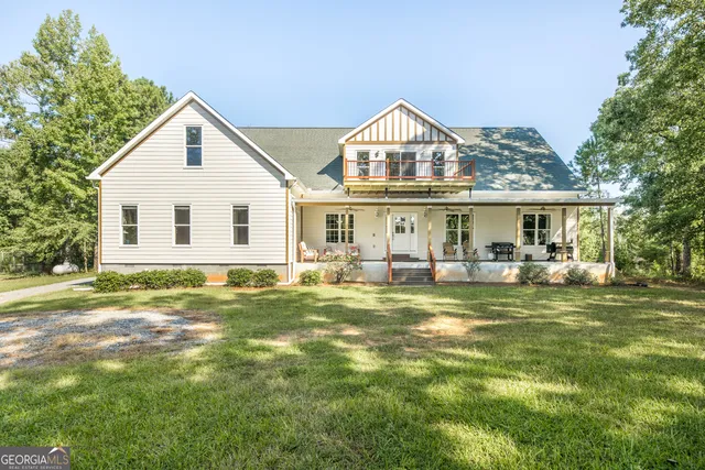 an aerial view of house with yard and trees in the background