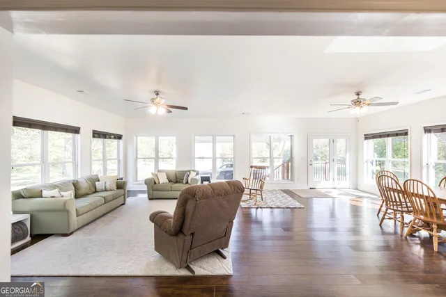 a living room with furniture a ceiling fan and a window