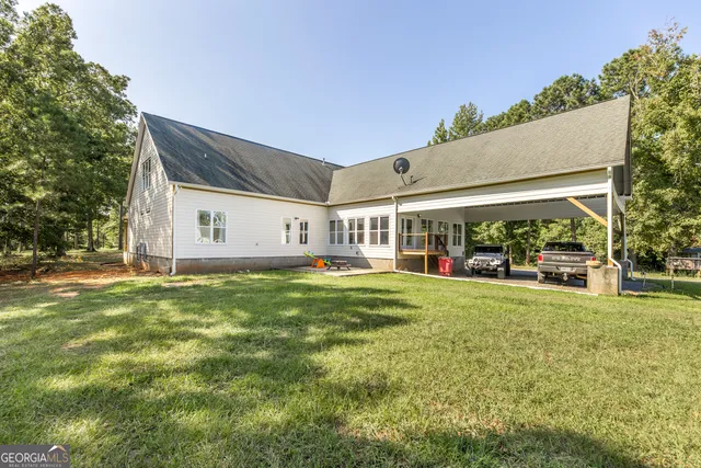 a view of backyard of house with wooden deck and seating space