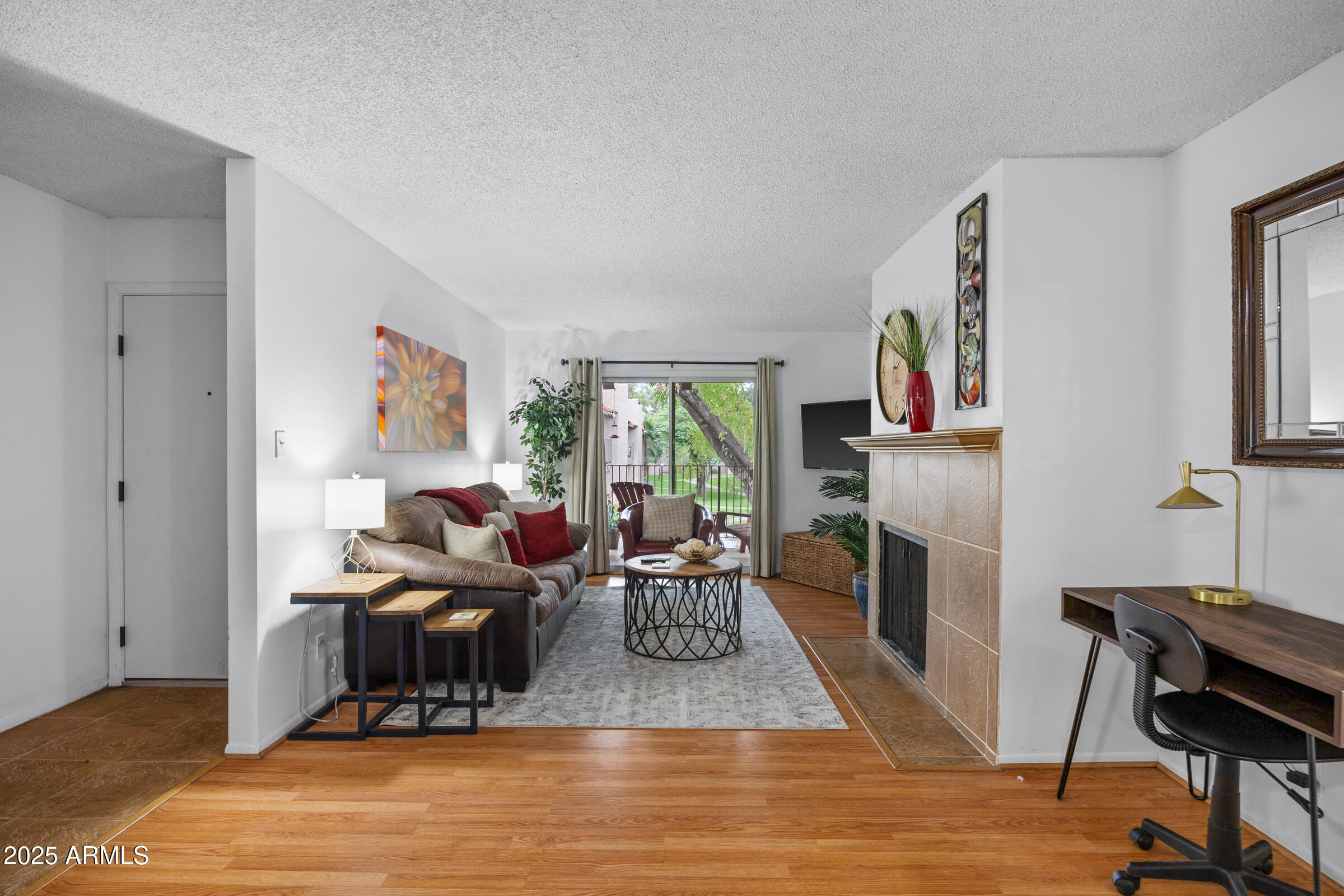 5525 East Thomas Road, Unit M11 Phoenix, AZ 85018 - Photo 34 of 39 a living room with furniture a fireplace and a flat screen tv