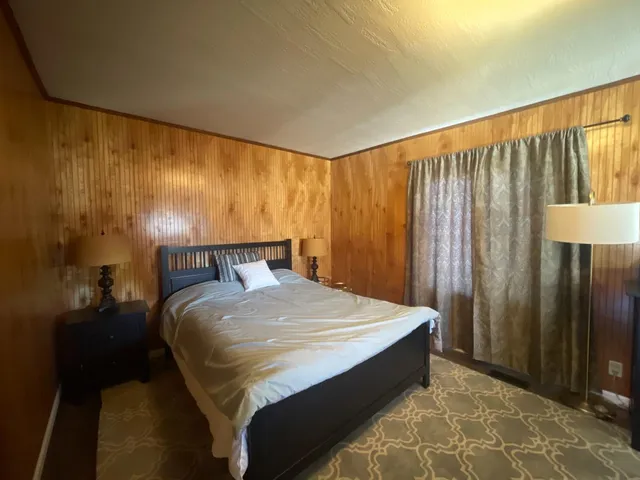 a bed sitting in a spacious bedroom next to a balcony