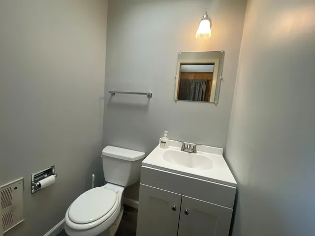 a bathroom with a toilet sink and mirror