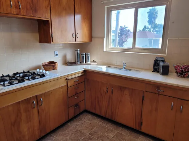 a kitchen with stainless steel appliances sink a window and cabinets