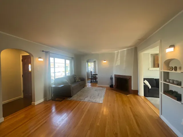 a view of a living room with furniture and wooden floor