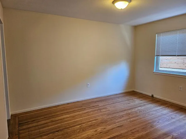 a view of a room with wooden floor and a sink