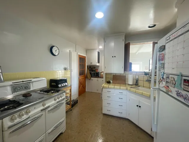 a kitchen with a stove a sink and a refrigerator