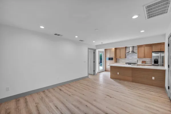 a kitchen with granite countertop stainless steel appliances a refrigerator and cabinets
