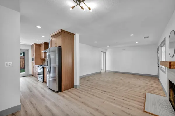 a view of kitchen with stainless steel appliances granite countertop cabinets and wooden floor